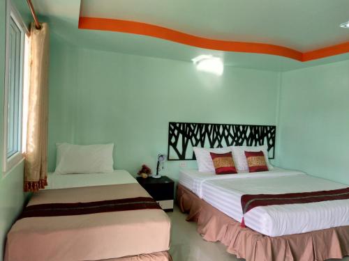 two beds in a room with blue walls at Phi Phi Coralbay in Phi Phi Islands