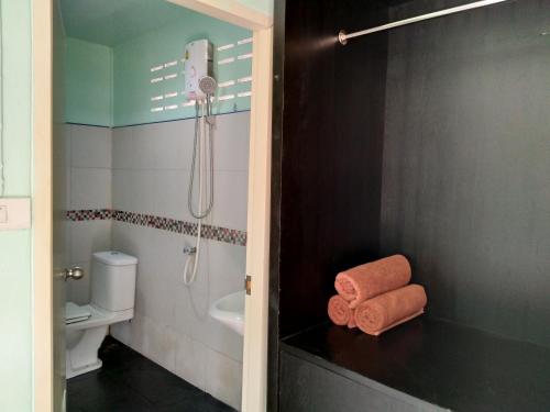 ein Bad mit einer Dusche und einem Handtuch auf der Theke in der Unterkunft Phi Phi Coralbay in Ko Phi Phi