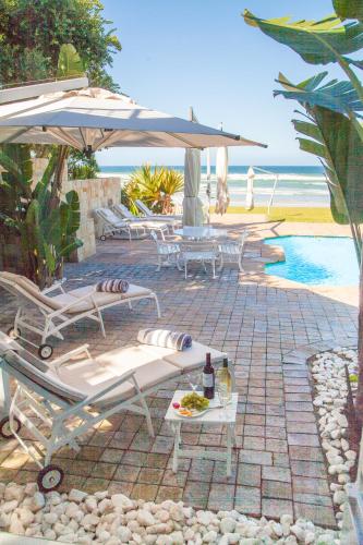 a patio with a table and chairs and an umbrella at Ti’amo in Wilderness