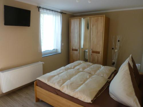 ein Schlafzimmer mit einem großen Bett und einem TV in der Unterkunft Welterbe Mittelrhein in Biebernheim