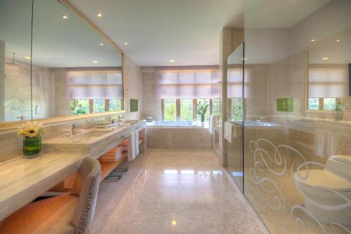 a large bathroom with two sinks and a tub at The Chateau Spa & Wellness Resort in Bukit Tinggi
