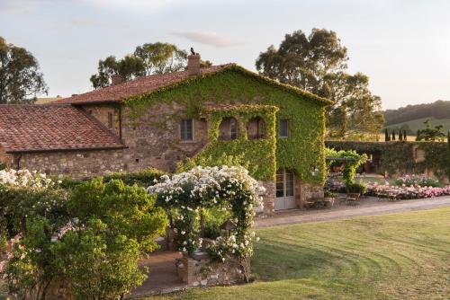 una casa vieja cubierta de hiedra con jardín en Relais Sant'Elena, en Bibbona