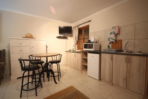 a kitchen with a table and chairs and a microwave at Eazy Sleep Accommodation in Swakopmund