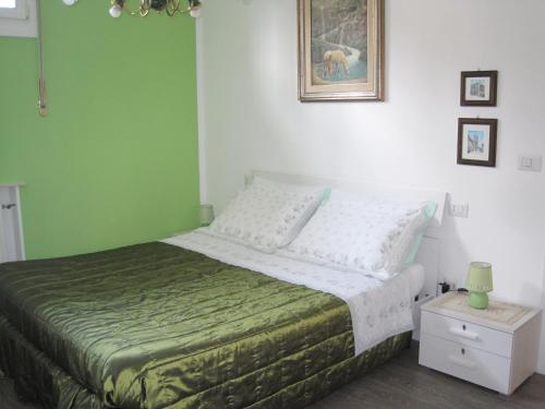 a bedroom with a bed with a green wall at Bed and Breakfast lo Scrigno in Polinago