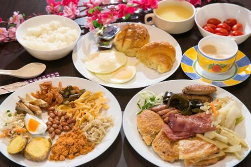 a table topped with plates of breakfast foods and coffee at Garden Spring Hotel in Jiaoxi