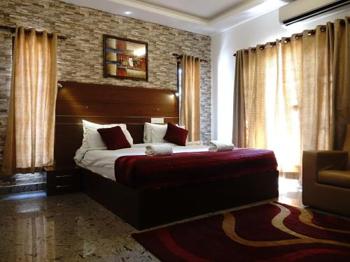 - une chambre avec un grand lit et un mur en briques dans l'établissement Fortkochi Beach Inn, à Cochin