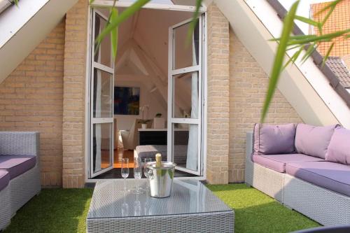 a patio with a table and chairs and a couch at Loft at Bruges in Varsenare