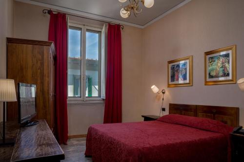 a bedroom with a red bed and a window at Hotel Kursaal & Ausonia in Florence