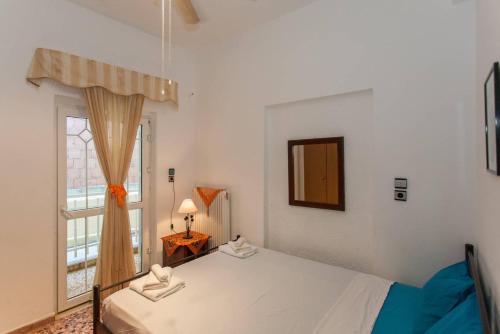 a bedroom with a white bed and a window at Apartment Froso on the Beach in Rethymno