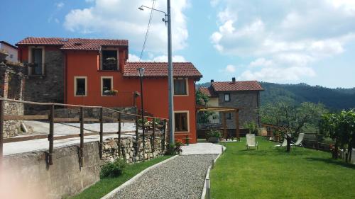 a house with a stone wall and a yard at Agriturismo Giumin in Rocchetta di Vara