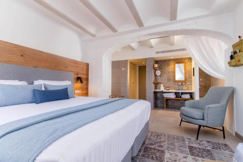 a bedroom with a large bed and a chair at La Serena Boutique Hotel & Wellness - Altea in Altea