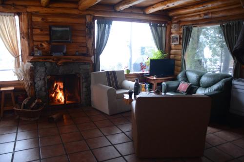 sala de estar con sofá y chimenea en El Aleph en Villa La Angostura