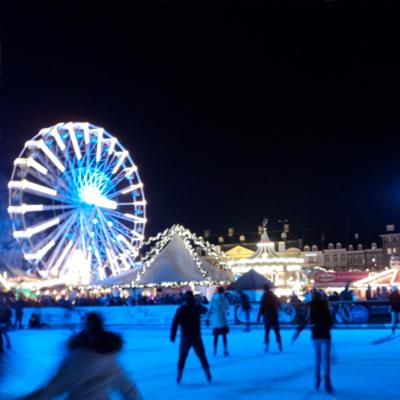 a ferris wheel and a group of people in the snow at Het Harlekijntje in Maastricht