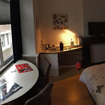 a living room with a table and a kitchen at Het Harlekijntje in Maastricht