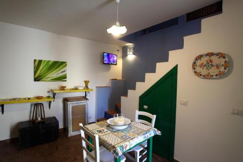 a room with a table and a green door and stairs at jusu e susu montagna mare in Mistretta