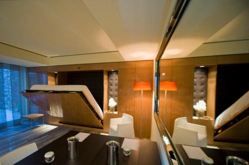 a room with chairs and a table and a mirror at Hotel Romano House in Catania