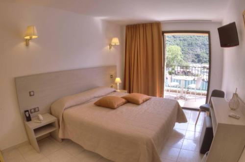 une chambre avec un lit et une grande fenêtre dans l'établissement Hôtel Le Romantique, à Porto Ota