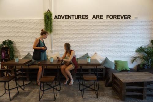 Twee vrouwen zitten aan tafels in een koffiehuis. bij Krit Hostel in Bangkok
