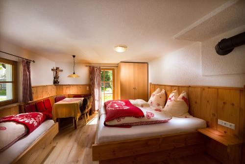 グロースアルルにあるBirnbaum Chalets Grossarlのベッドルーム1室(ベッド2台、赤と白の枕付)