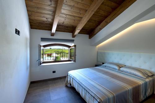 um quarto com uma cama grande e uma janela em Casale905 em Crecchio
