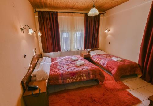 um quarto de hotel com duas camas e uma janela em Lefteris em Alatópetra