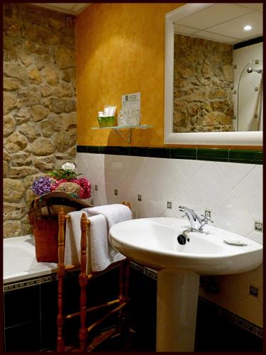 a bathroom with a sink and a mirror at Posada La Cotía in Helguera