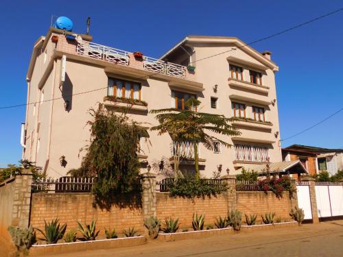 duży biały dom z ceglaną ścianą w obiekcie Antsirabe Hotel w mieście Antsirabe