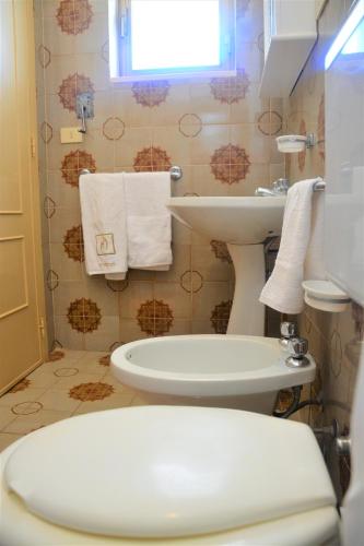 a bathroom with a toilet and a sink at Leca's House Appartamenti a 100m dal mare in Gagliano del Capo