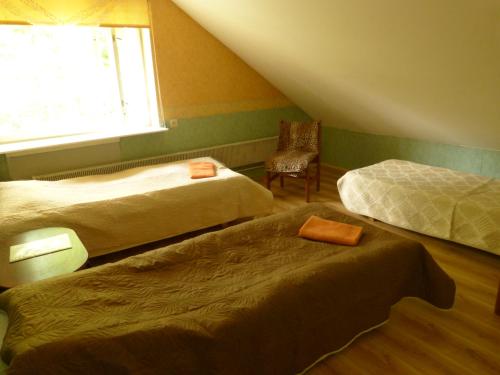 a room with two beds and a chair and a window at Viva Pirita Hostel in Tallinn