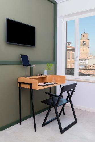 a desk with a laptop and a chair in a room at BnBiz - Coworking Hotel in Fiorenzuola dʼArda
