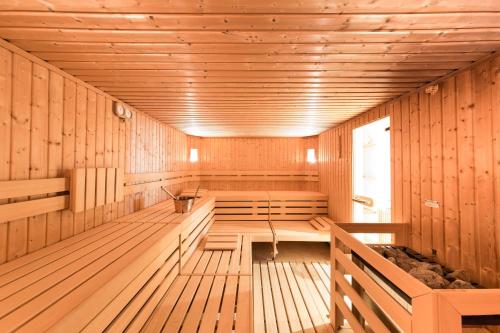 an empty sauna with wooden walls and wooden benches at Pöder - daheim in den Bergen in Ultimo