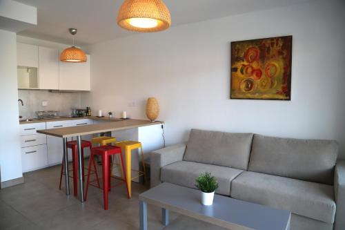 eine Küche und ein Wohnzimmer mit einem Sofa und einem Tisch in der Unterkunft Naiades appartement in Le Lavandou