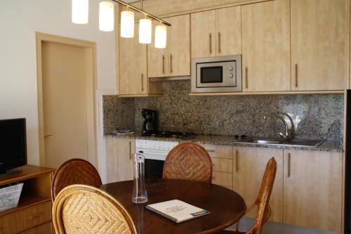 a kitchen with a table and chairs and a microwave at Apartaments Ocean Canada in Platja d'Aro