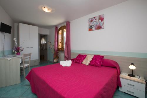 1 dormitorio con 1 cama rosa grande con sábanas rosas en B&B Oliva, en Scala