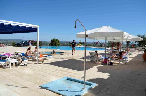 a group of people sitting around a swimming pool at Santarem Hotel in Santarém