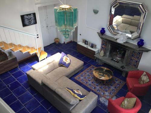 uma sala de estar com um sofá e um espelho em Attico Blu em Nápoles
