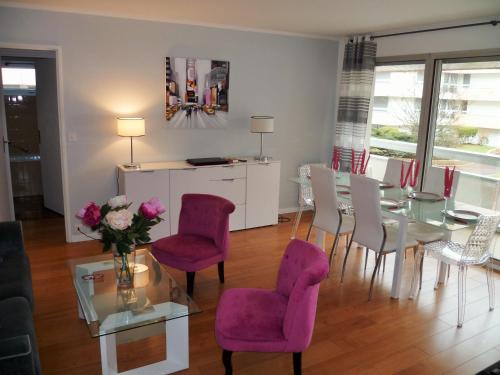 ル・テュケ・パリ・プラージュにあるResidence les Serresのリビングルーム(ダイニングテーブル、紫色の椅子付)