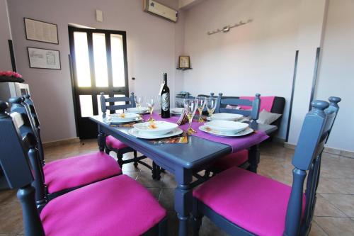 a table with purple chairs and a bottle of wine at Apartment Marko in Rovinjsko Selo