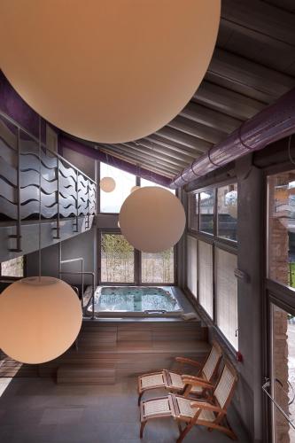 a room with chairs and a swimming pool in a building at Boutique Hotel Villa dei Campi in Gavardo