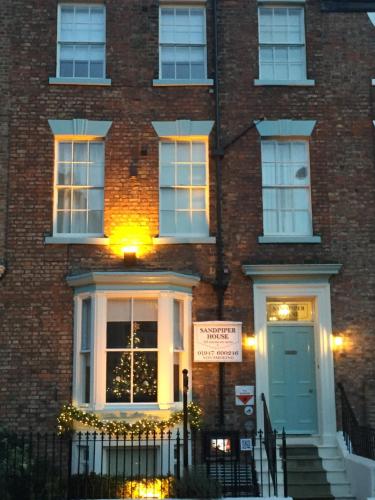 a brick building with a door and a sign on it at Sandpiper House in Whitby