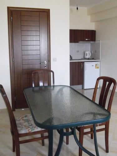 a dining room table with two chairs and a kitchen at Calypso Luxury Studios in Vasiliki