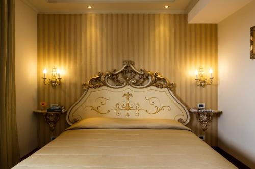 a bedroom with a large bed with a gold headboard at Villa Tuscolana in Frascati