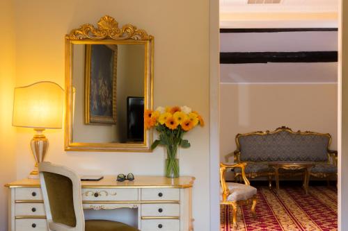 a room with a vase of flowers on a dresser and a mirror at Villa Tuscolana in Frascati