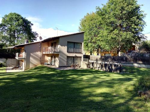 a house with a grass yard in front of it at Cal Cisteller in Santa Pau