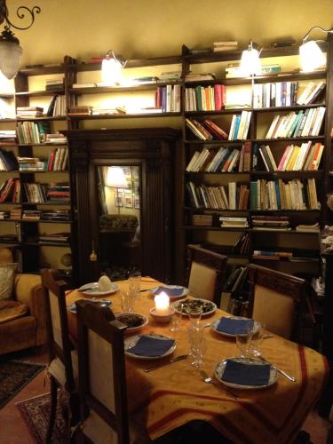 a table in a room with a library with books at Palazzetto Bentivoglio in Sassoferrato