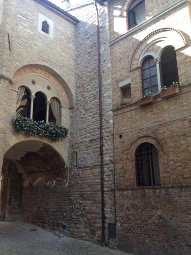 an old brick building with two windows and a courtyard at Palazzetto Bentivoglio in Sassoferrato