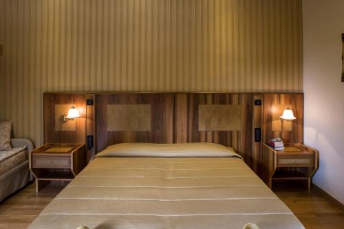 a bedroom with a large bed with two night stands at Villa Tuscolana in Frascati