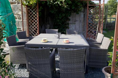 une table extérieure avec des chaises et un tableasteryasteryasteryasteryasteryasteryasteryasteryastery astery dans l'établissement La Petite Chesnee, à Sacey