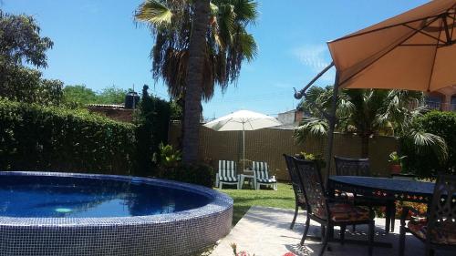 a pool with a table and chairs and an umbrella at Delfin in Cruz de Huanacaxtle