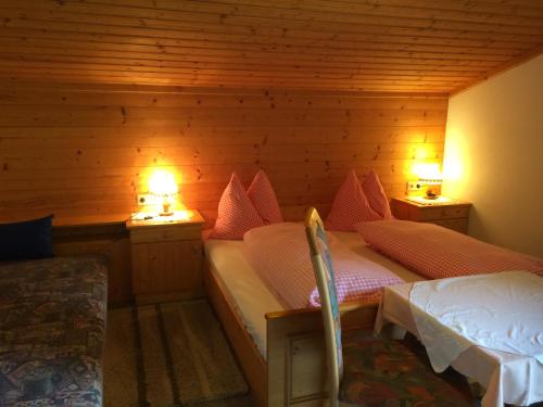 1 dormitorio con 2 camas y 2 luces en 2 mesas en Vorderjetzbachhof, en Maria Alm am Steinernen Meer